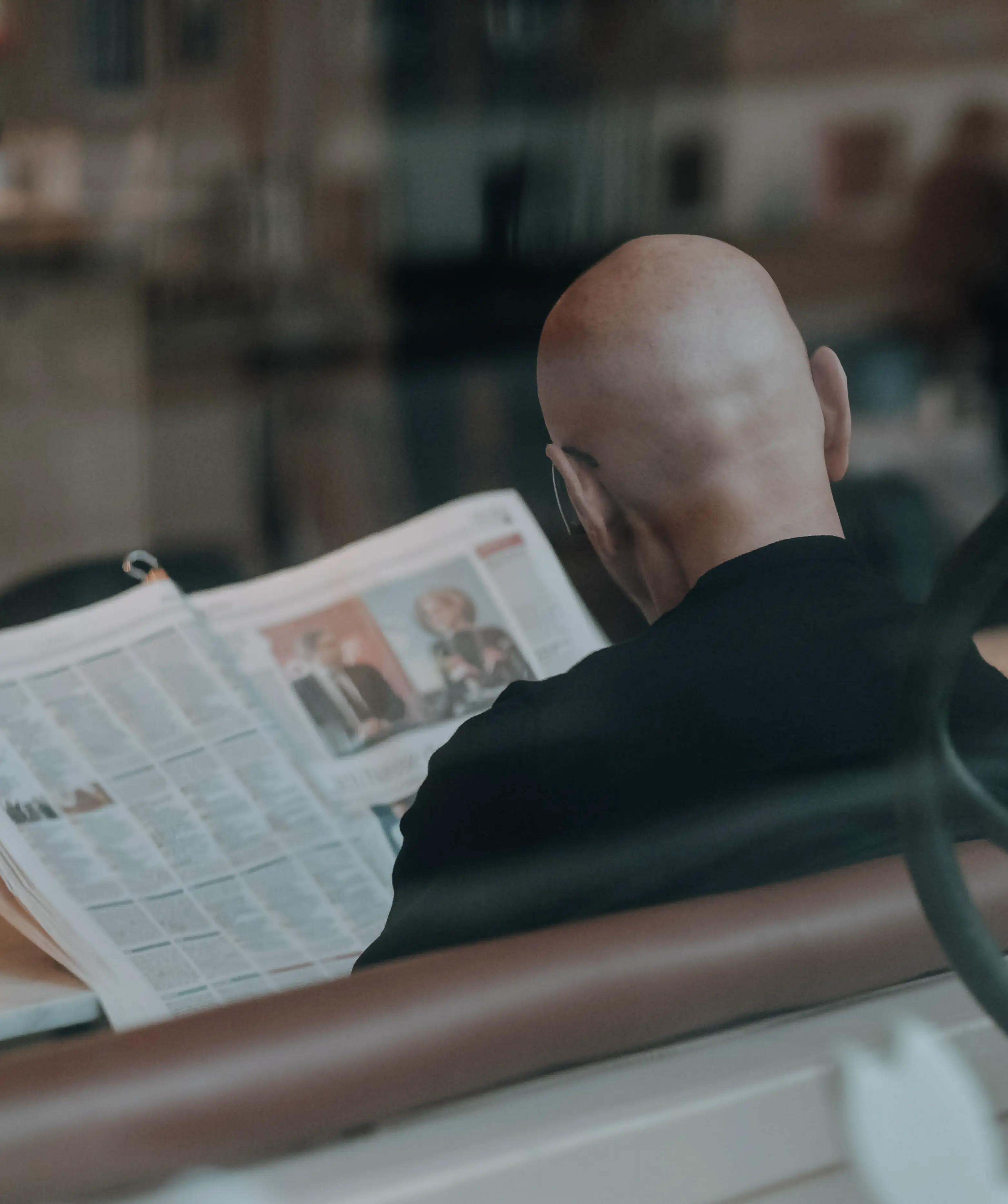 Un homme de dos qui lit son journal